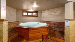 Un jacuzzi en una habitación con paredes de madera y una ventana.