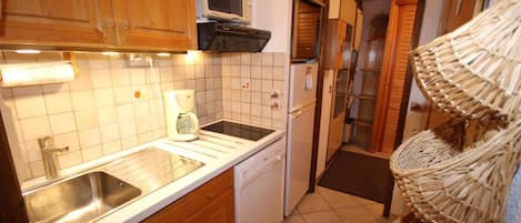 A compact kitchen with a sink, a microwave, and a coffee maker.