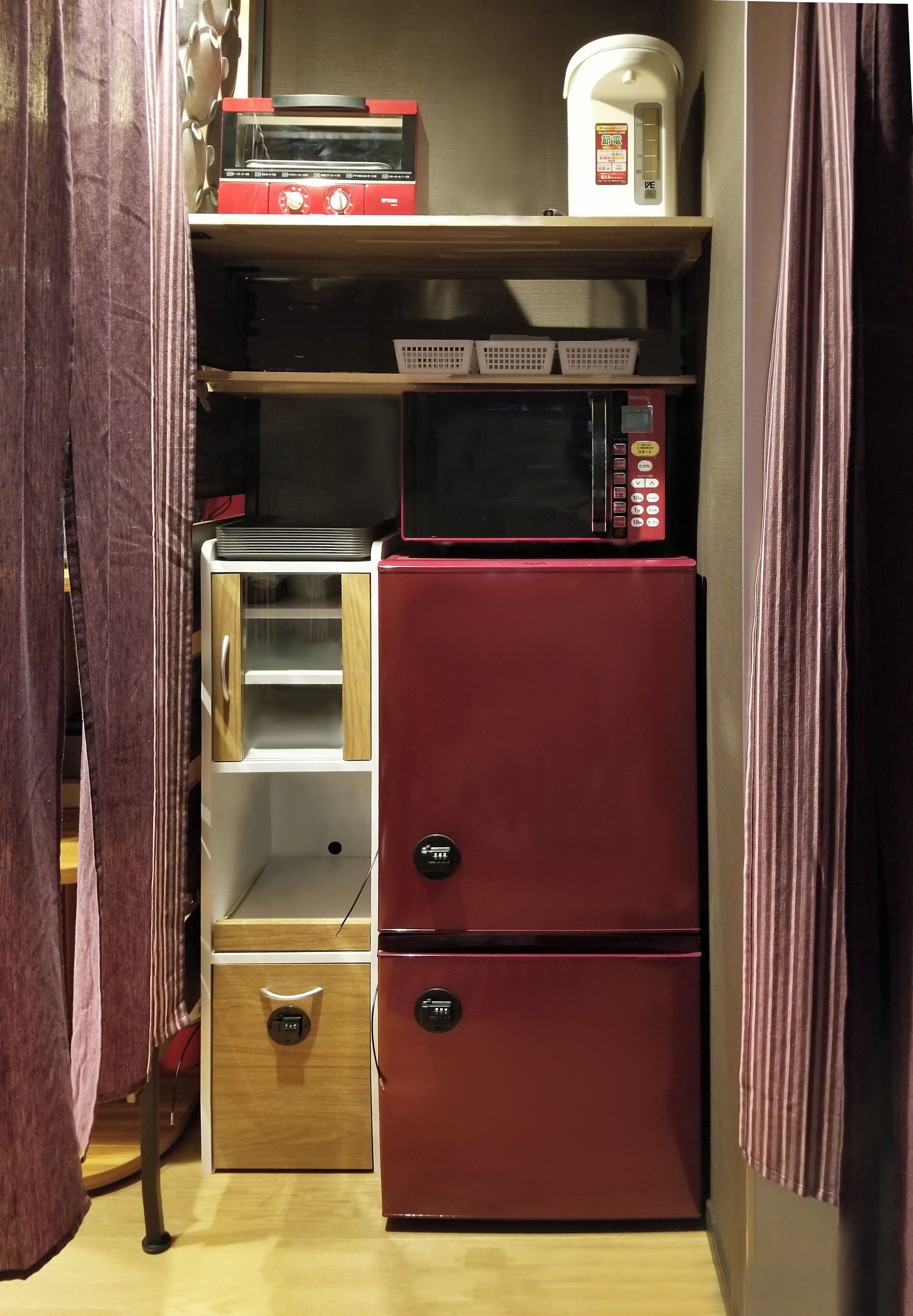 Une petite cuisine équipée d’un four à micro-ondes, d’un grille-pain et d’un petit réfrigérateur.