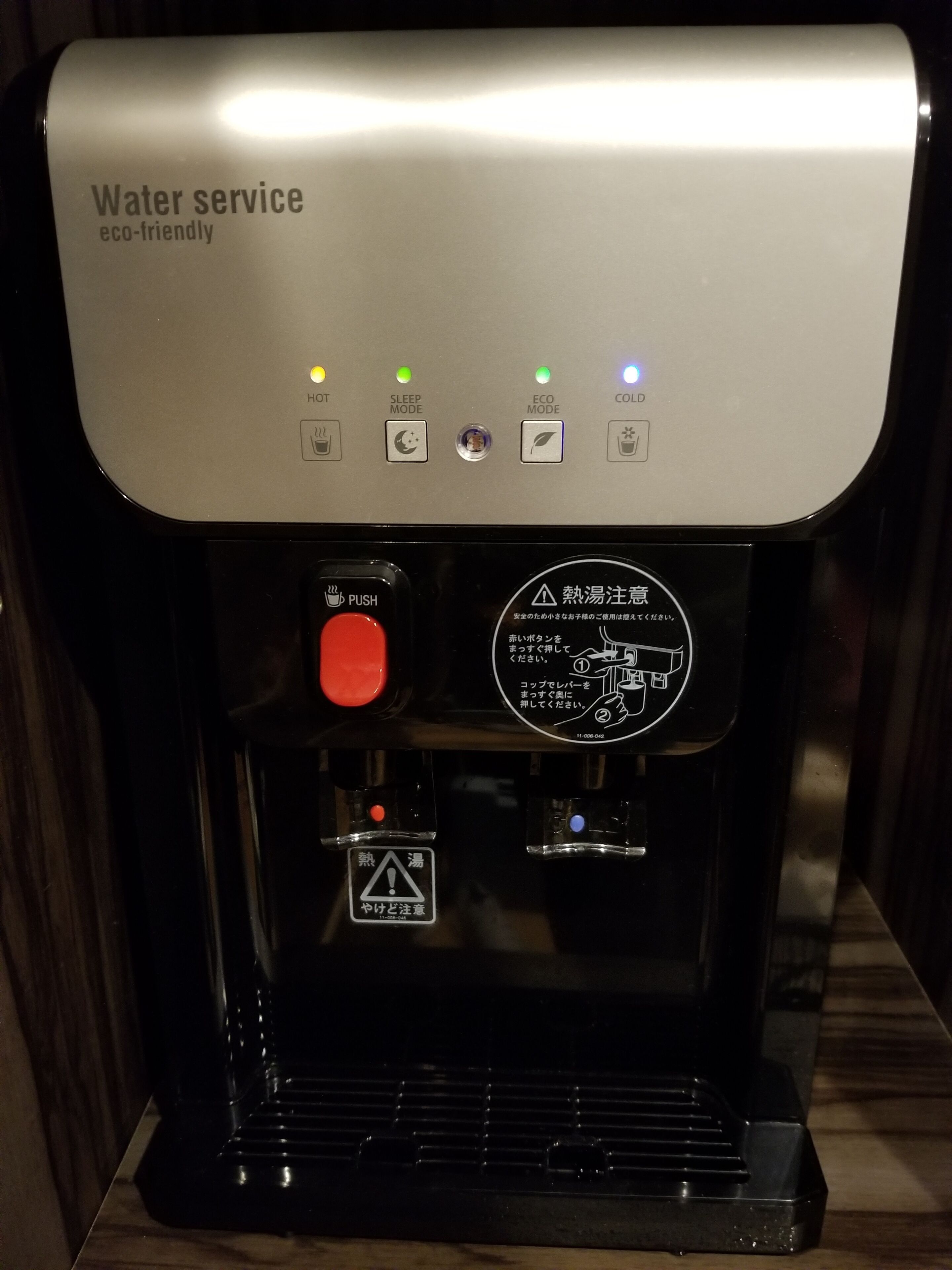 A water service machine with eco-friendly options, a hot water button, a sleep mode, and a cold water button.