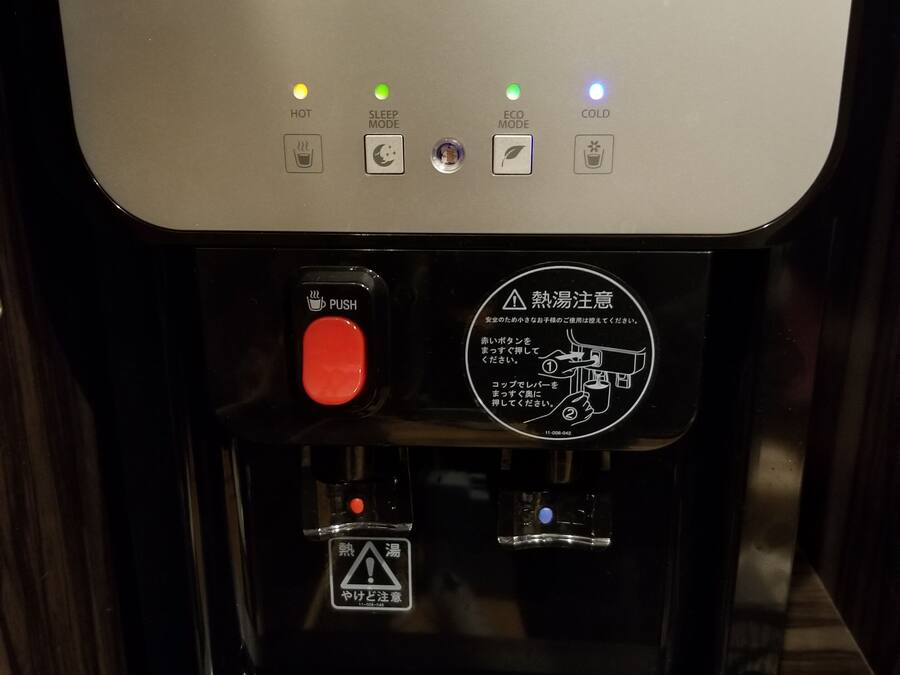A water service machine with eco-friendly options, a hot water button, a sleep mode, and a cold water button.