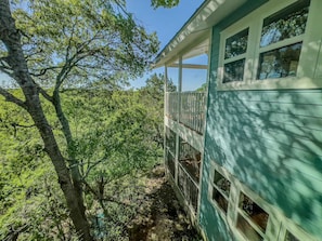 Surrounded by lush greenery, this two-story building offers a serene retreat with a spacious balcony overlooking the natural surroundings.