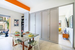 Un comedor con una mesa dispuesta para cuatro, una estantería y un armario corredero.