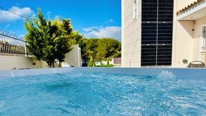 A swimming pool with a clear blue water surface, surrounded by a white wall and a fence. - Airfenos - Luxury home in the Athens Riviera, Greece. (Anavissos)