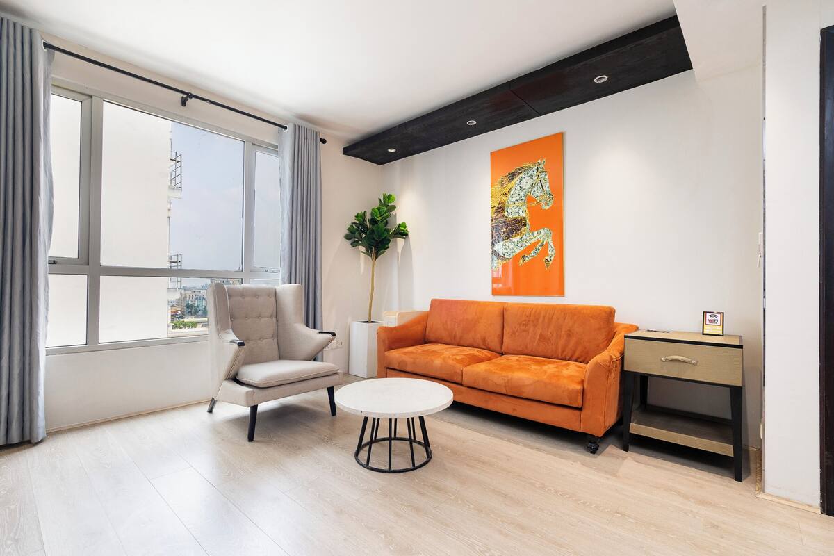 Een moderne woonkamer met een bank, fauteuil en een klein rond tafeltje.
