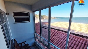 Un balcon avec vue sur la plage et l’océan.
