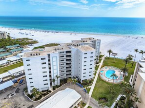 A high-rise hotel with a pool, beach view, and multiple balconies.