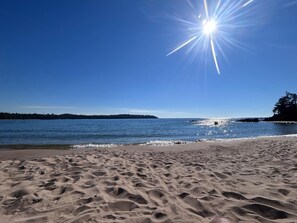 Une plage avec un ciel dégagé et une eau calme.