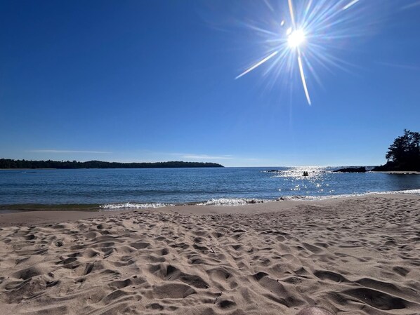 Una playa con cielo despejado y agua tranquila.
