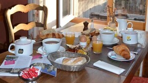 Une table de petit-déjeuner avec un croissant, des œufs et une théière.