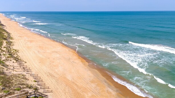 A beach with a wooden walkway and beach chairs. - Cottage Close To Beach and abuts the Wright Brother Memorial (Kill Devil Hills)