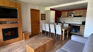 Una sala de estar moderna con una mesa de centro de madera, un sofá gris y un comedor con sillas.
