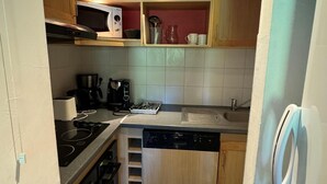 A compact kitchen with a microwave, stove, coffee maker, and dishwasher. - Ski-in/ski-out & foot of the slopes, 3rd floor, view ski slopes, swimming pool, balcony, tv (La Plagne)