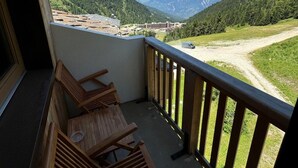 A balcony with wooden chairs and a view of a mountainous landscape. - 7th floor, view ski slopes, swimming pool, balcony, tv, ski locker, 41m², La Plagne (La Plagne)