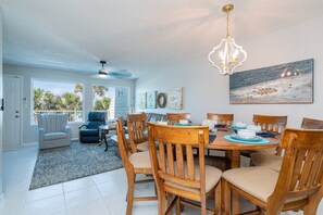 A dining area with a wooden table, chairs, and a chandelier. - Beachfront 3BR Townhouse Not a Condo! Pet Friendly (Panama City Beach)