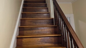 Un escalier en bois avec une rampe et un tableau accroché au mur.