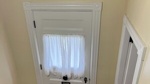 Une porte blanche avec une petite fenêtre et une poignée de porte.