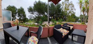 Relax in a serene outdoor space surrounded by lush greenery and shaded by a large umbrella.