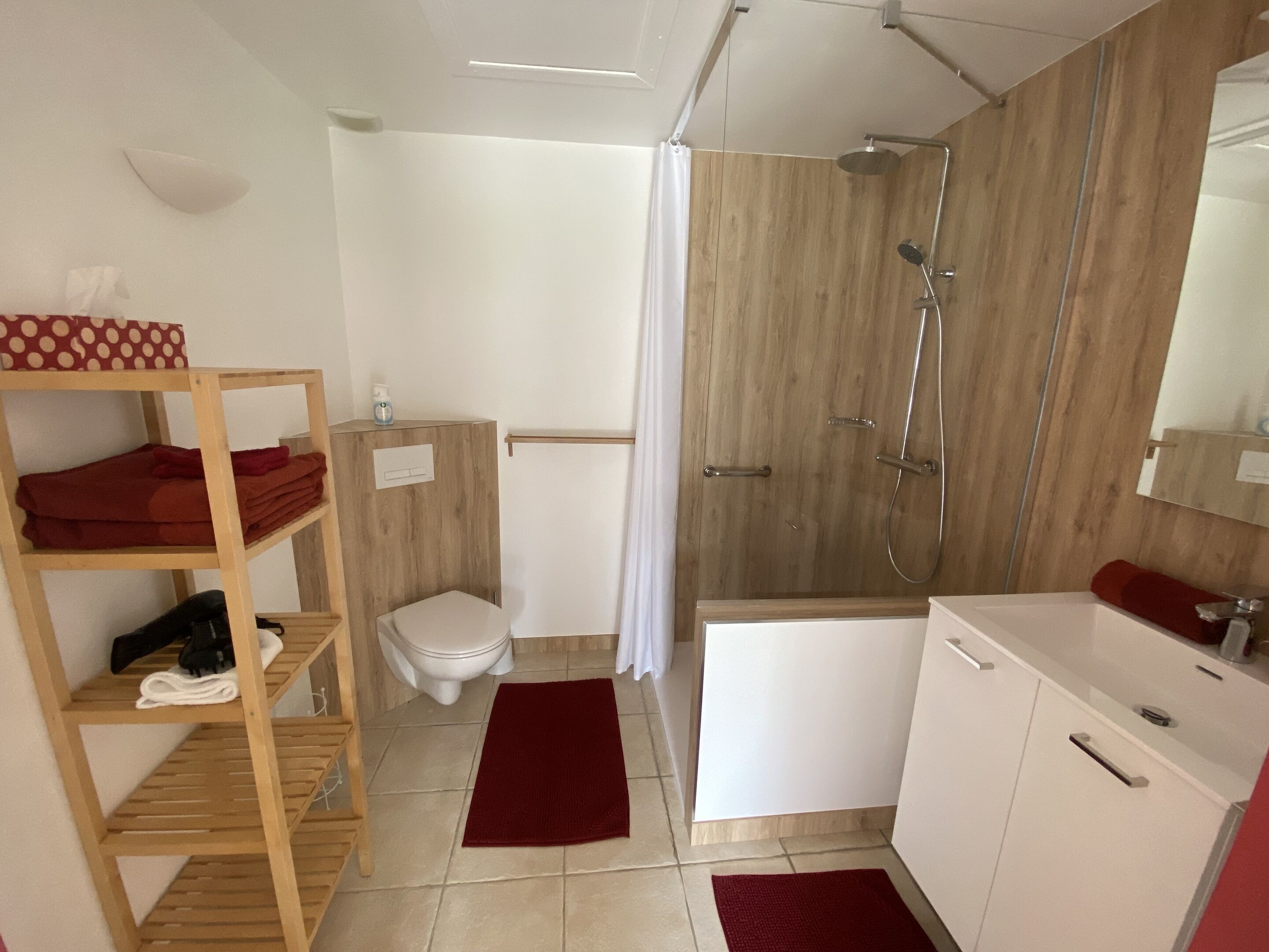 A compact bathroom with a shower, toilet, and sink.