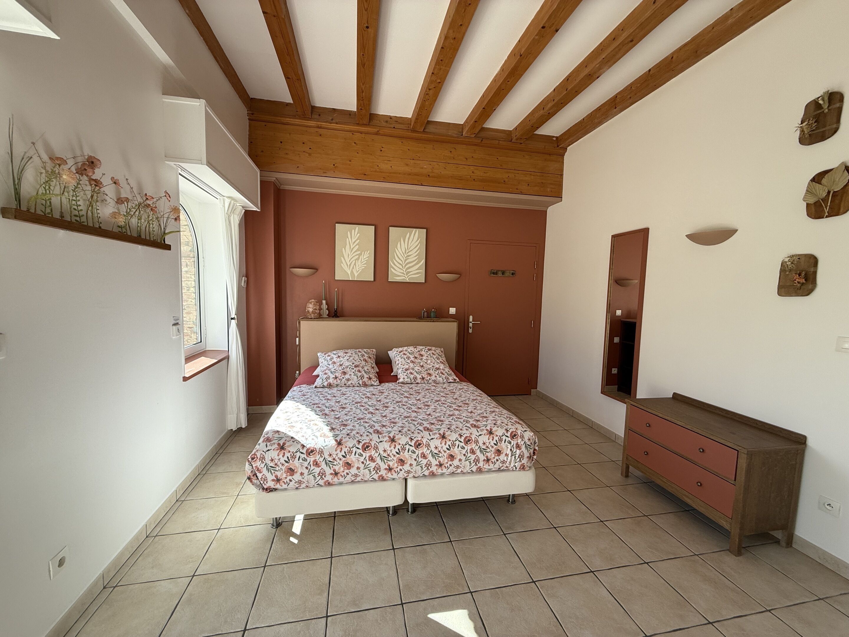 Un dormitorio con cama, cómoda, espejo y ventana.