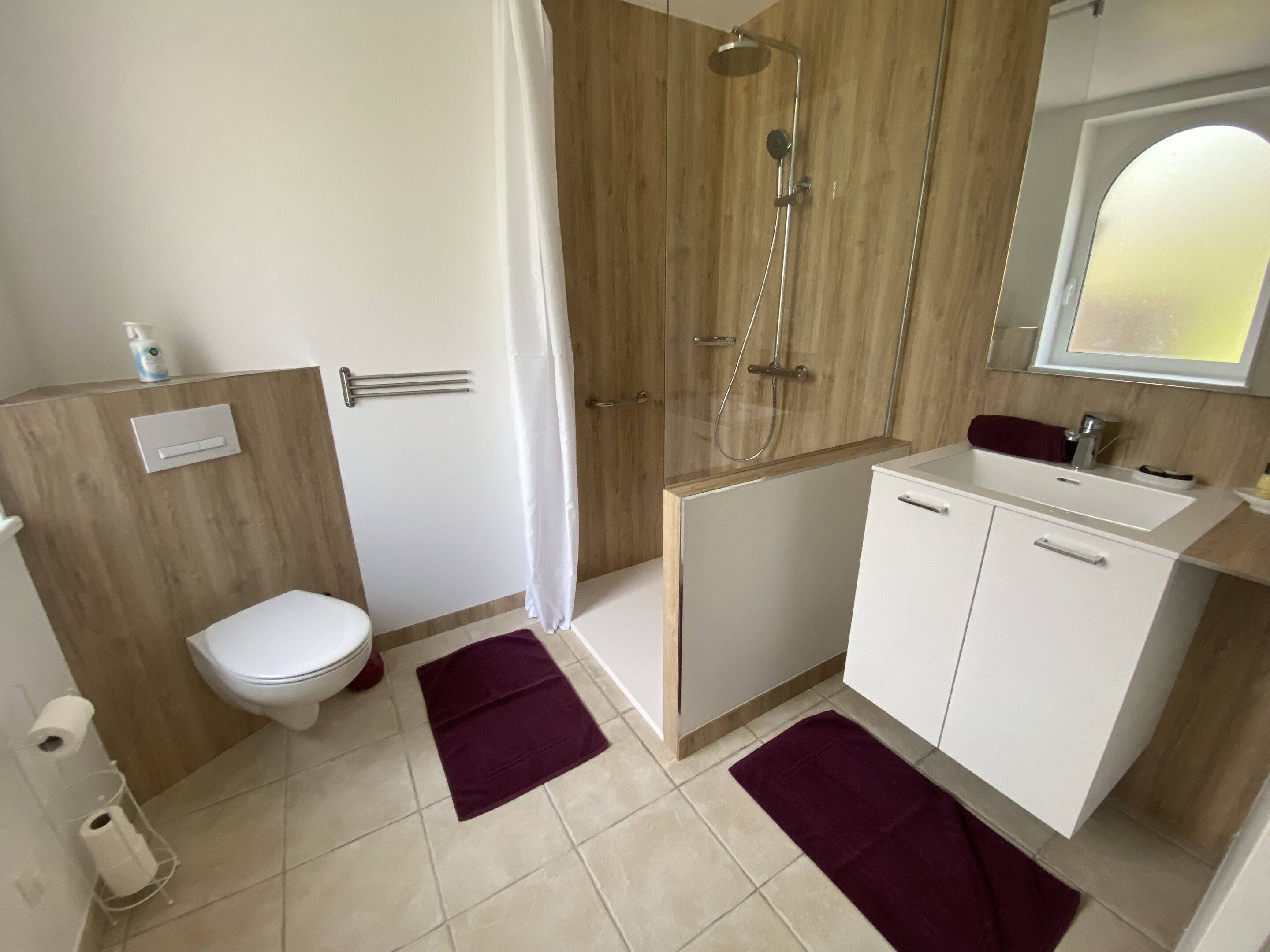 Un baño moderno con inodoro, ducha y lavamanos.