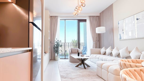 A modern living room with a sectional sofa, a coffee table, and a large window with curtains. - Elegant 1B Apt&balcony in the Heart of Dubai Creek (Dubai)