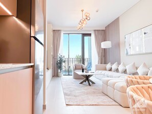 A modern living room with a sectional sofa, a coffee table, and a large window with curtains. - Elegant 1B Apt&balcony in the Heart of Dubai Creek (Dubai)