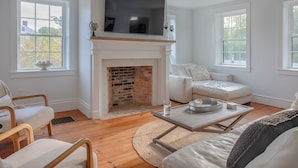 A living room with a fireplace, a television, and a sofa. - Historic Charm & Modern Comfort, Beach Vacation Awaits. (Wells)