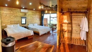 Une pièce aménagée comme un chalet en bois, avec deux lits, une table et une chaise.