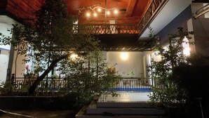 Un espace extérieur doté d’un balcon en bois, d’un escalier et d’une rambarde.