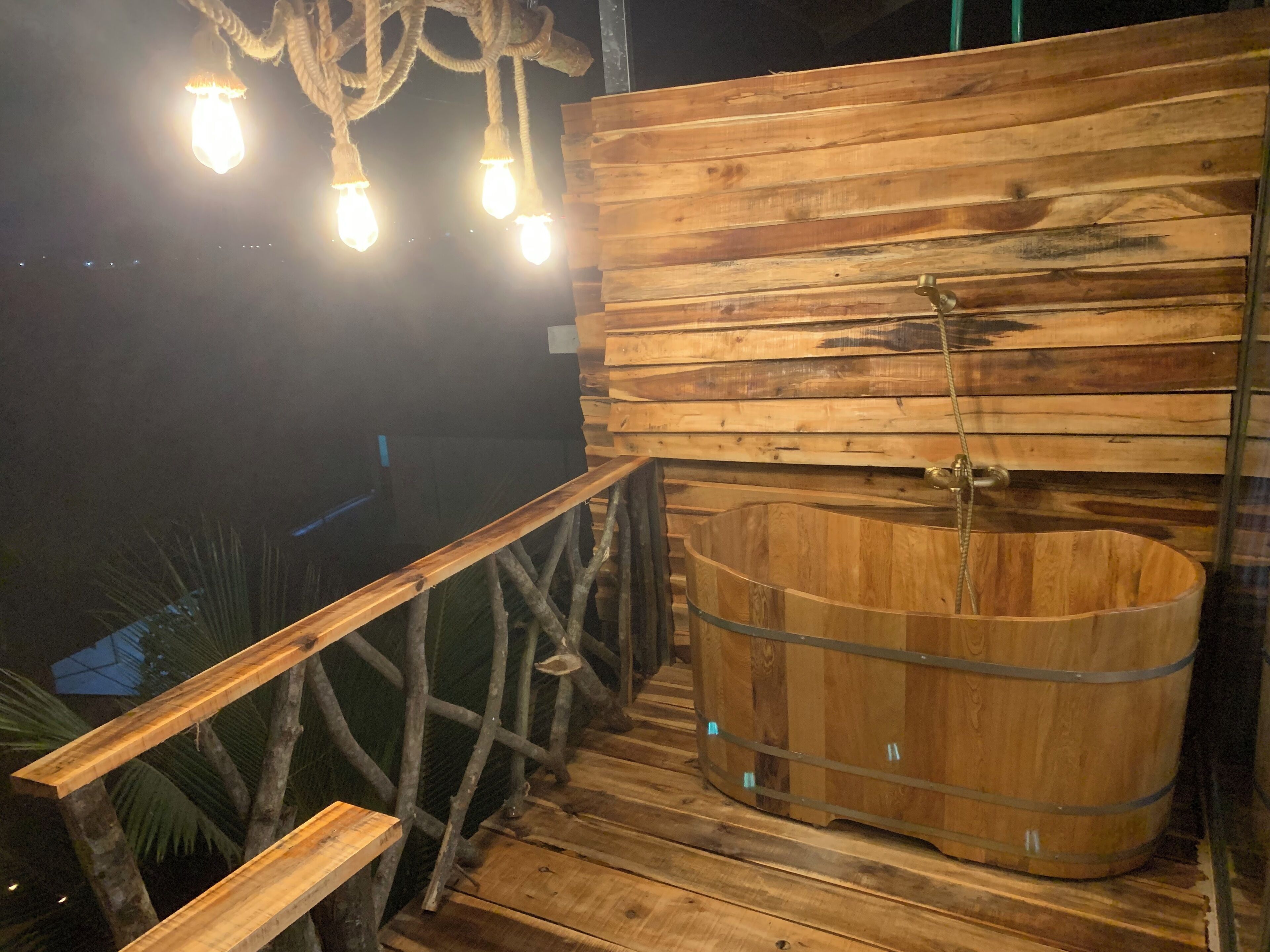 A wooden deck with a hot tub and a bench.