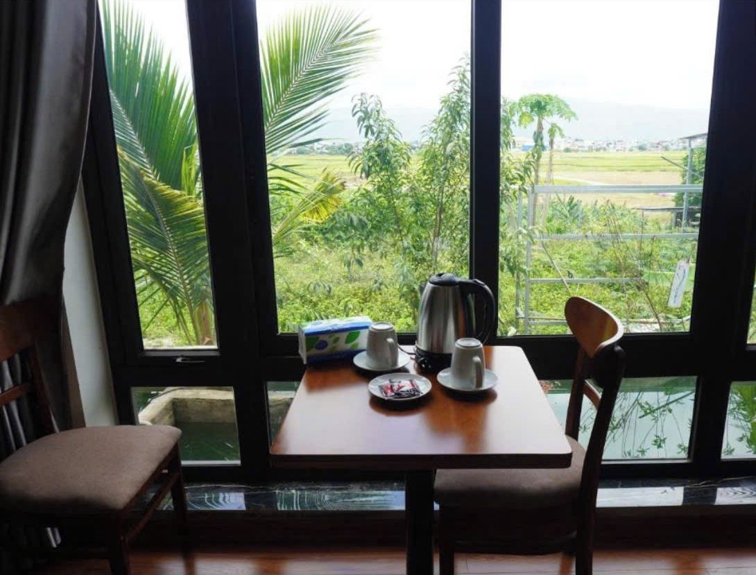 Una habitación con una mesa dispuesta para dos personas, un hervidor, tazas y una caja de pañuelos.