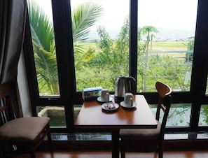 A room with a table set for two, a kettle, cups, and a box of tissues. - A Thia Homestay (Muong Thanh)