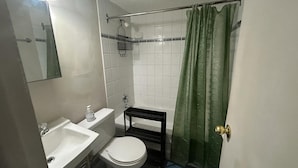 Un baño pequeño con inodoro, lavabo y zona de ducha.