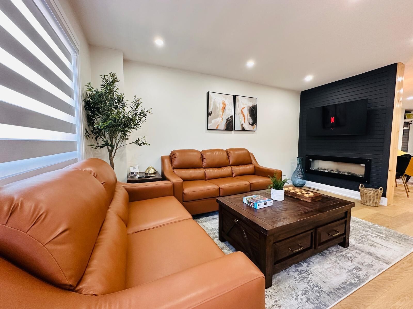 Un salon moderne avec un canapé d’angle, une table basse et une cheminée.