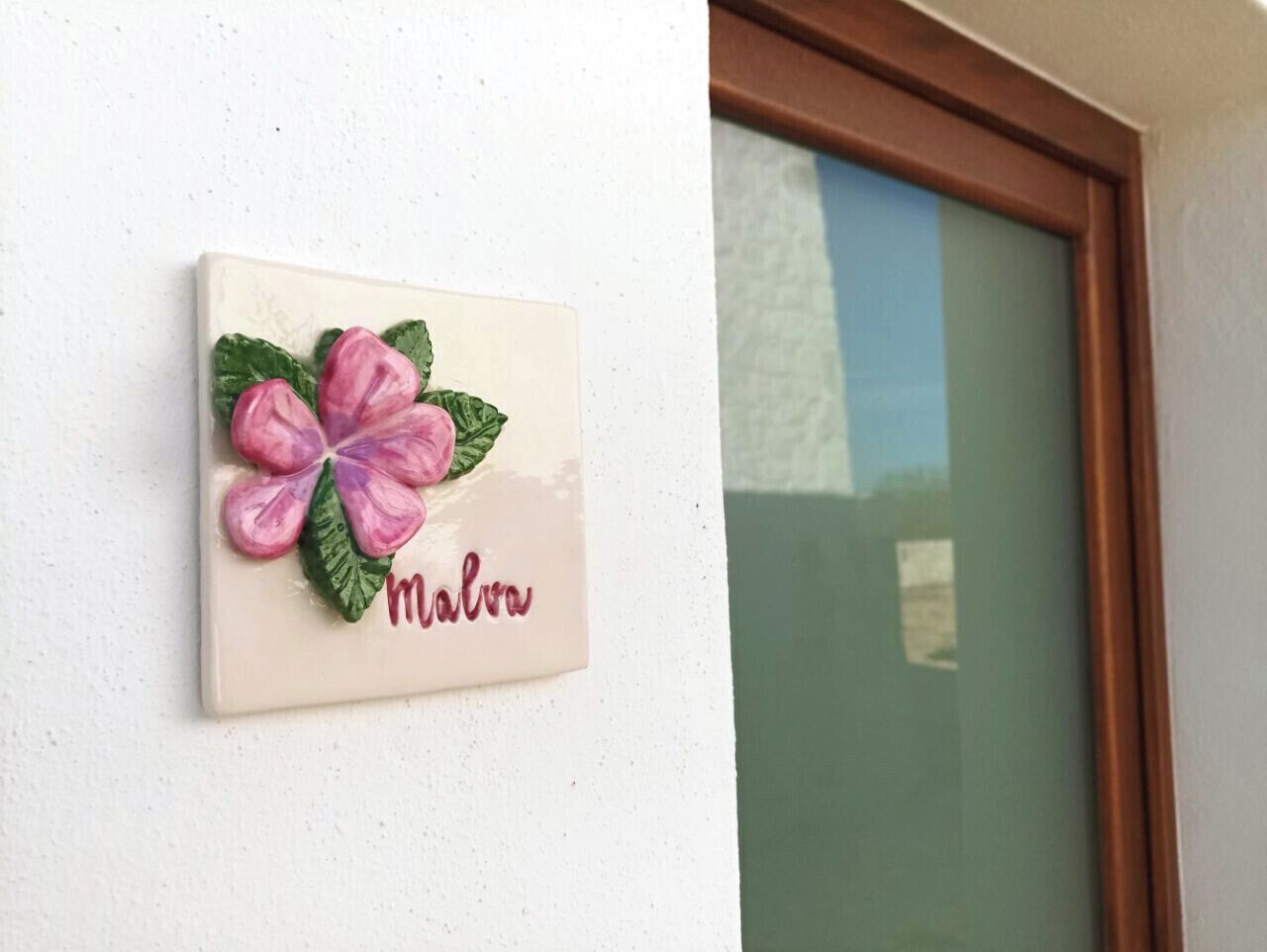 Un letrero en la pared con una flor y el nombre 'Malva'.