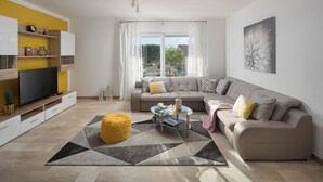 A modern living room with a sofa, a glass coffee table, and a yellow ottoman. - Romantic villa with istrian tavern (Labin)