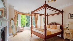 A four-poster canopy bed in a room with a large window, a mirror, and a small bedside table. - Chelsea Parkfields  (Ross-on-Wye)