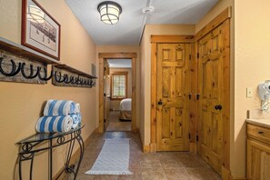Enter a serene bedroom through this tranquil hallway, featuring a comfortable bed and a stylish window with blinds.
