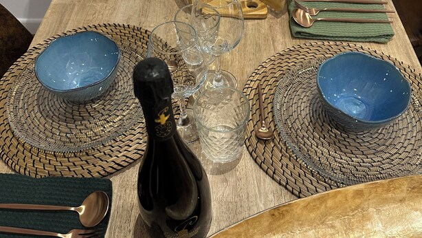 A dining table set with blue bowls, clear glasses, wooden utensils, and a bottle of wine. - Tarraco Civitas ubi ver Aeternum Est. Totalmente Reformado y con Ascensor (Tarragona)
