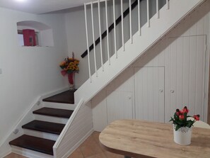 A staircase with white railings and dark wooden steps leading to a landing.