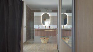A modern bathroom with a vanity, mirror, and a basket on the floor.