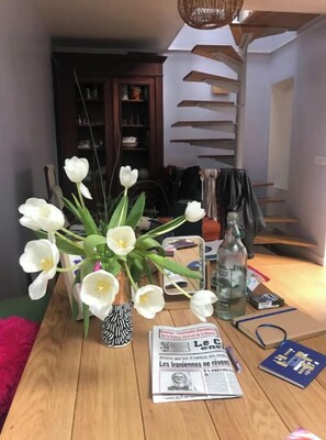 Relax in this inviting space with a comfortable table setting and beautiful flowers.