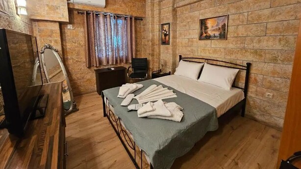A room with a bed, a TV, a desk, and a chair. - Honeywell Comfort Stay (Markopoulo Mesogaias)
