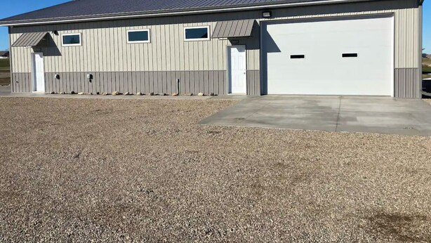 A single-story building with a flat roof and a large garage door. - Newly built in Devils Lake, Perfect for Fishing or Relaxing.   (Devils Lake)