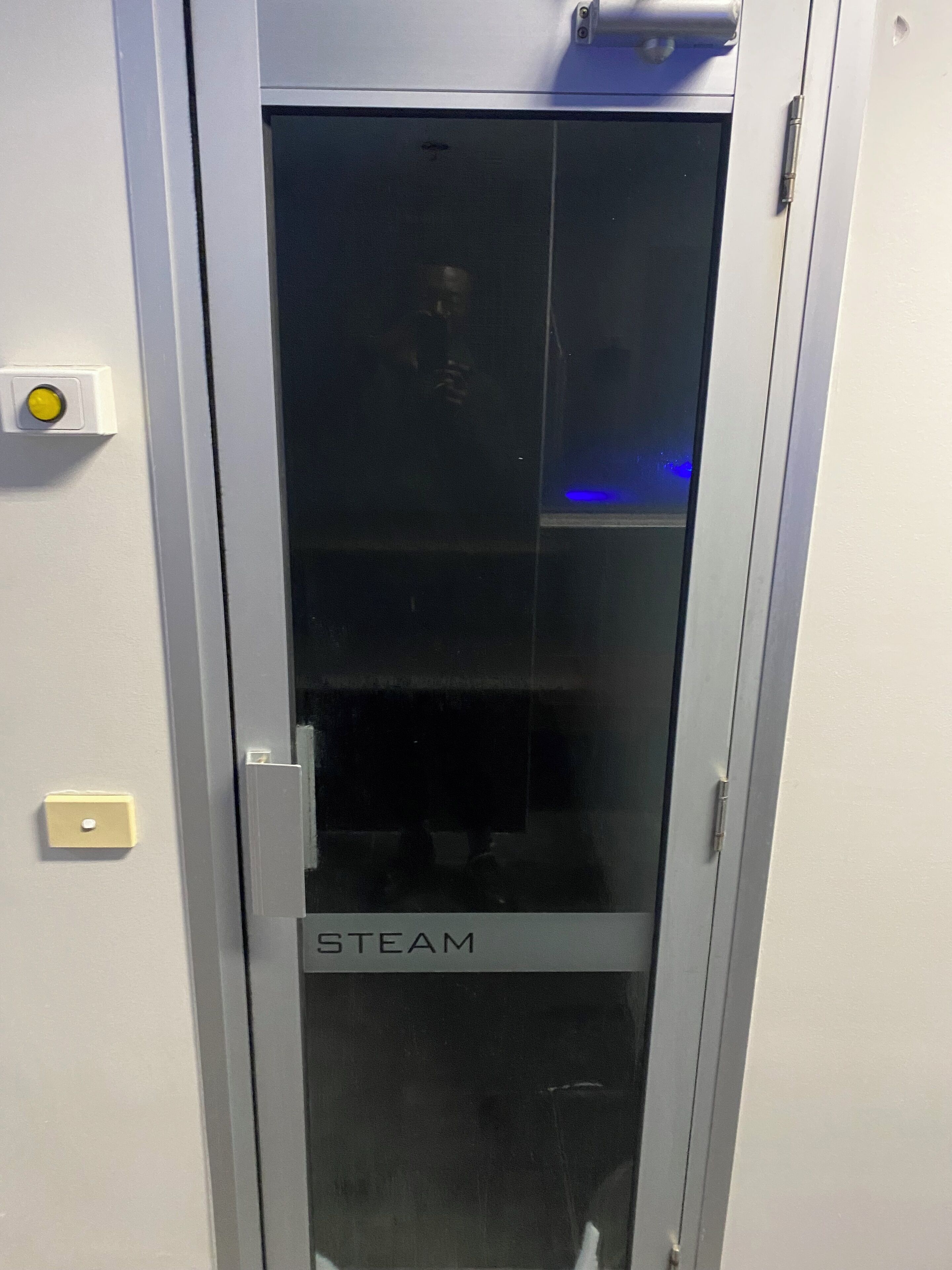 A door with a glass panel and the word "STEAM" on it.