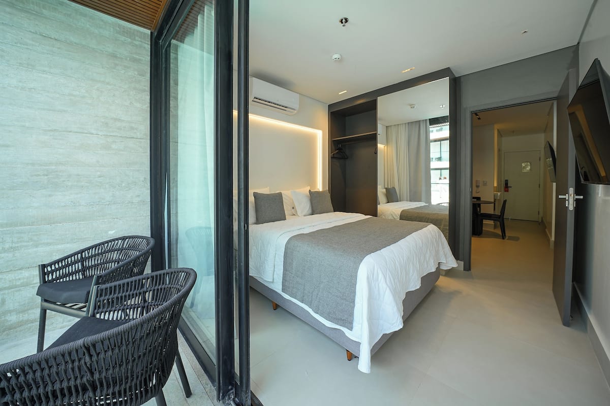 Une chambre à coucher moderne avec un grand lit, une petite table et une chaise.