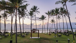 An outdoor seating area with tables and chairs, surrounded by palm trees, overlooking the ocean. - Porto Alto - GAV Hotéis e Resorts (Ipojuca)