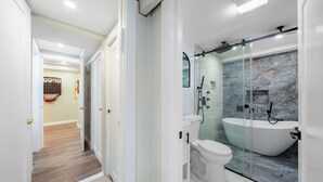 A modern bathroom with a glass-enclosed shower, a freestanding bathtub, and a toilet. - 16 shower Head Stay Luxury Stay (Passaic)