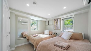 A bedroom with two beds, a large window, and an air conditioning unit. - 16 shower Head Stay Luxury Stay (Passaic)